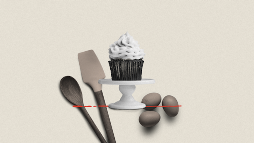 A cupcake on a serving tier with baking ingredients in the background.