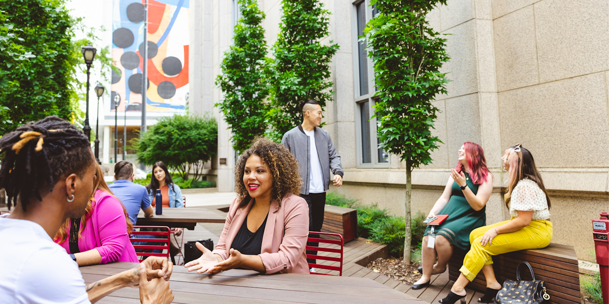 Professionals sit in an outdoor courtyard