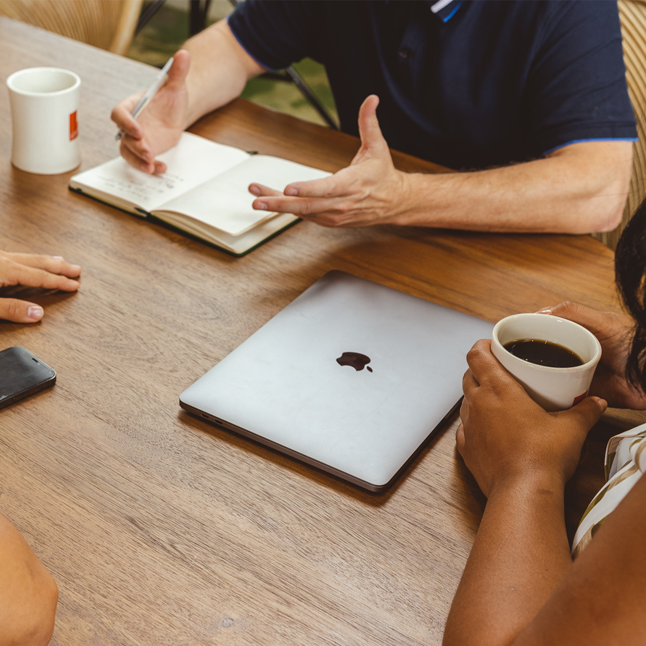 A meeting of people surrounding a laptop