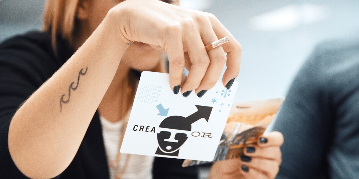 A person holds up a card that reads "Creator" - a brand archetype.
