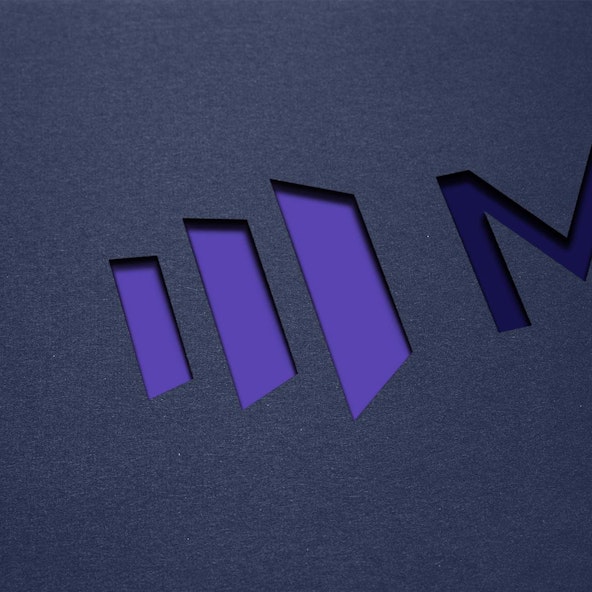 The Marketo logo diecut out of black paper.