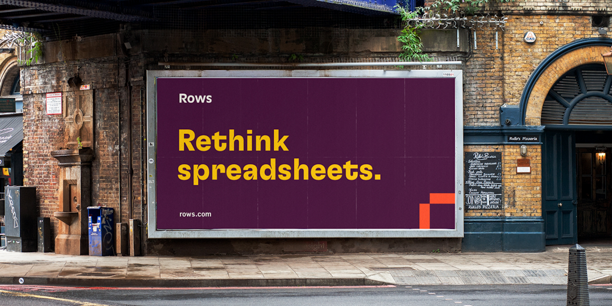 A billboard in an urban area that reads "Rethink spreadsheets."